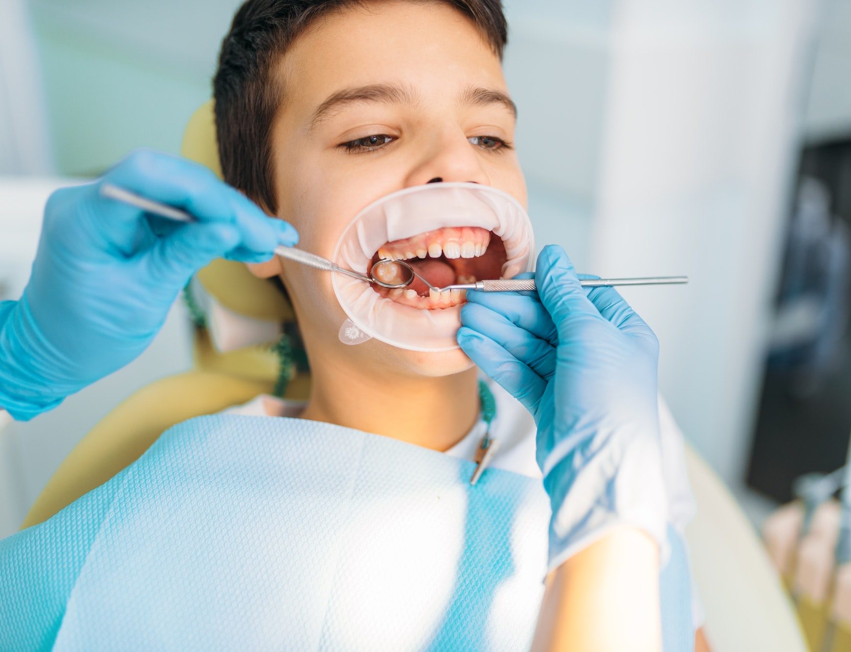 Boy in a dental cabinet, caries removal