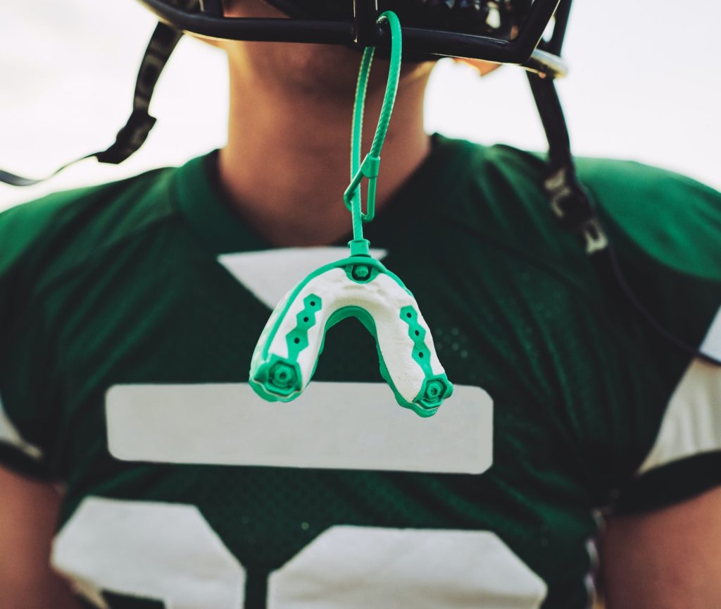 Mouthguard hanging off the helmet of an American football player